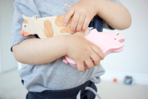 toddler with holztiger cow and pig